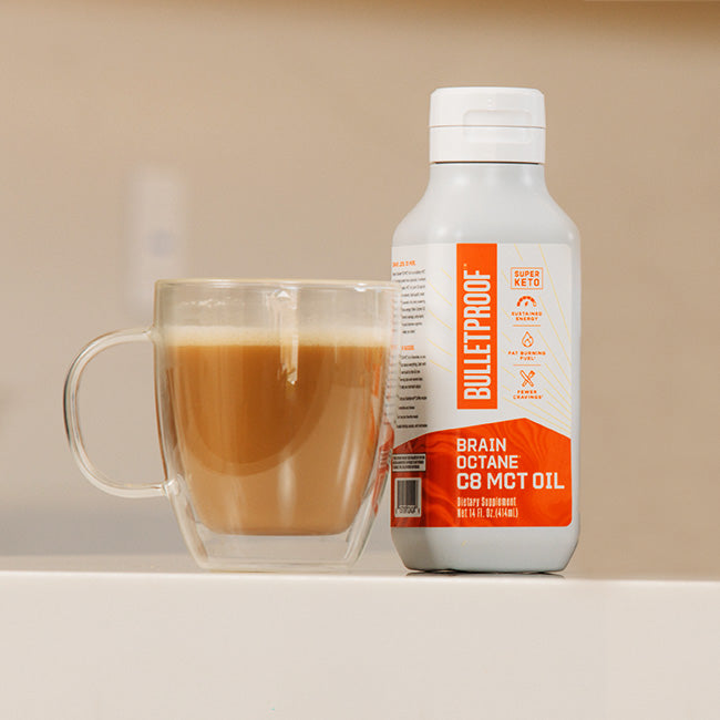 Bulletproof Brain Octane C8 MCT Oil next to coffee mug