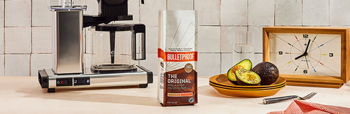 Bulletproof The Original Ground Coffee sitting next to coffee brewer and avocado