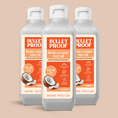 Three bottles of Bulletproof brain octane mct oil on a beige background