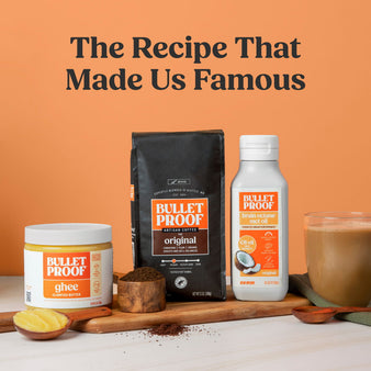 Bulletproof products on wood cutting board including coffee, oil, and ghee with a mug of coffee on an orange background