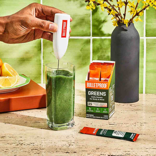 Bulletproof Greens packets being stirred into water with Bulletproof frother