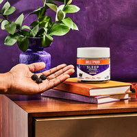 Bulletproof Sleep Gummies on nightstand with serving size in hand