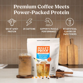 Bulletproof coffee packaging with iced coffee on a kitchen counter. Premium coffee meets power-packed protein. 12g of whey protein, 2x caffeine,. supports muscle performance†, no artificial flavors or sweeteners.