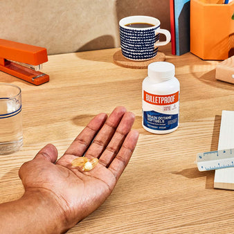 Open palm with serving size of Bulletproof Brain Octane Softgels on work desk