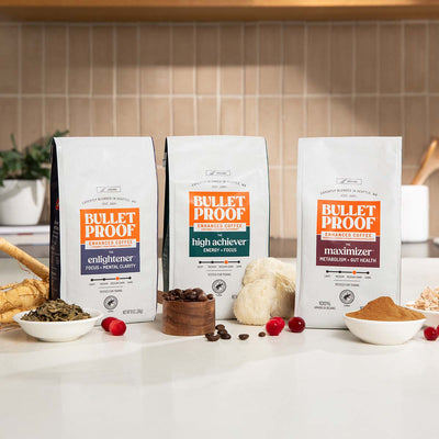 Three packages of Bulletproof coffee on a kitchen counter with ingredients.