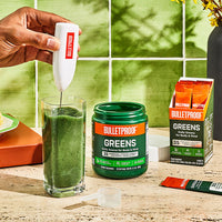 Bulletproof Greens powder being frothed into water glass