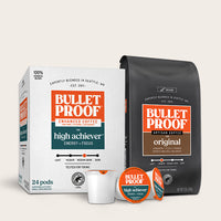 Bulletproof coffee packaging including a box, bag, and single serve pods on a light beige background.