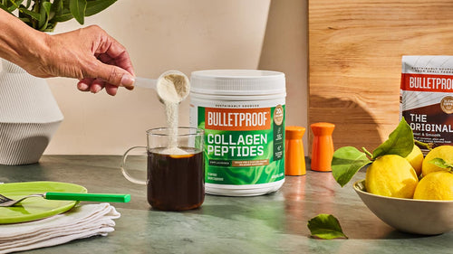 Scoop of Bulletproof collagen peptides dumping into coffee mug
