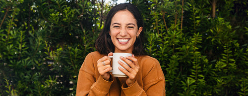 Woman smiling holding mug of Bulletproof Coffee