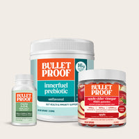 Three Bullet Proof products including a supplement, prebiotic powder, and gummies on a light beige background.