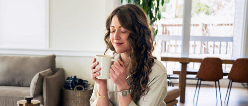 Woman holding a mug in a cozy living room